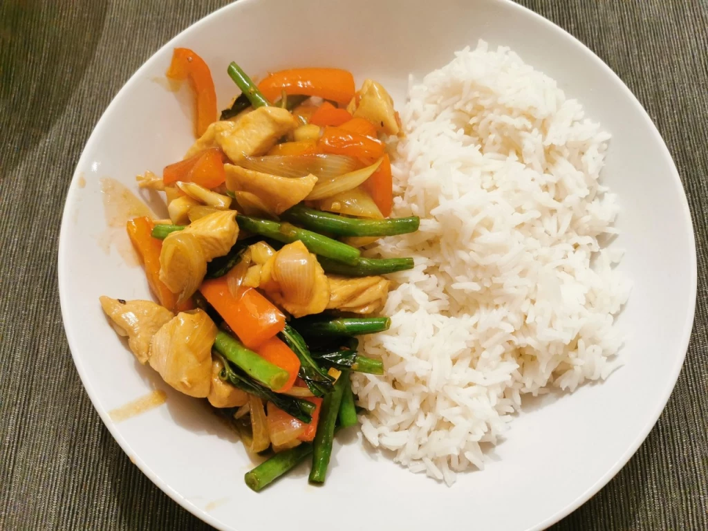 Hähnchen aus dem Wok in Pfeffer-Knoblauch-Sauce und Thai-Basilikum