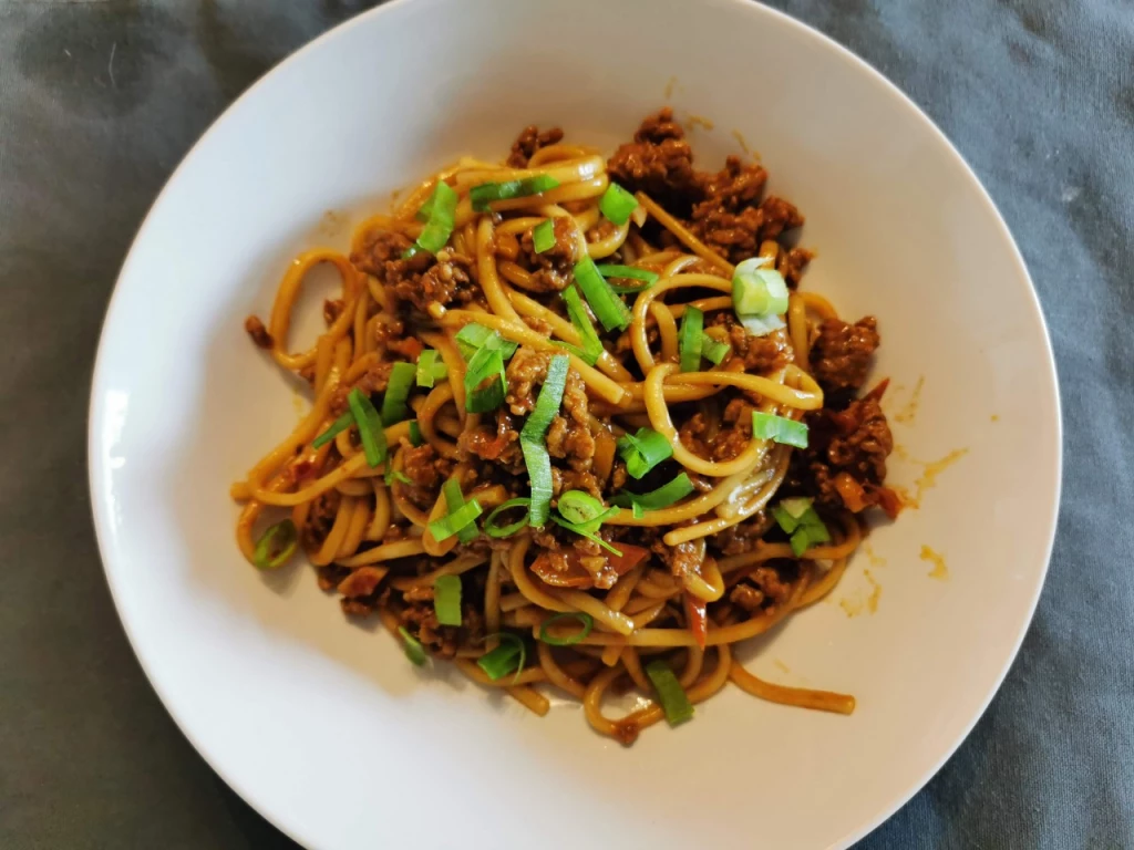 Udon-Nudeln mit Szechuan-Hack-Sauce und Tomaten