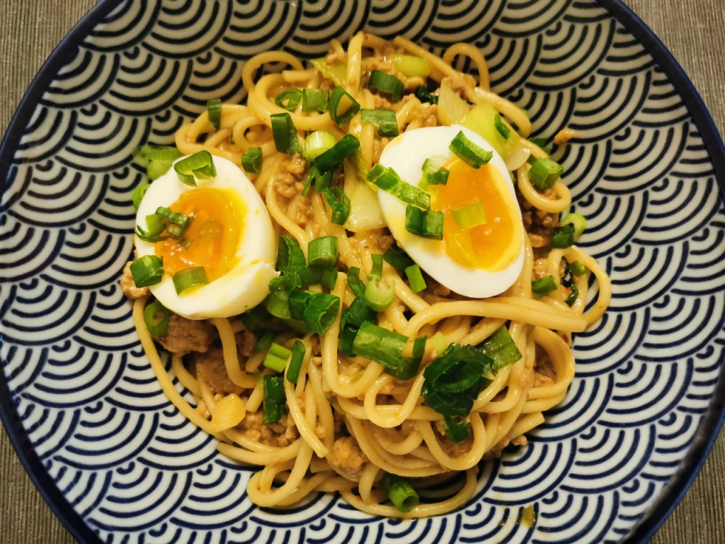 Udon-Nudeln mit Hackfleisch und Wachs-Ei in Erdnuss-Sauce